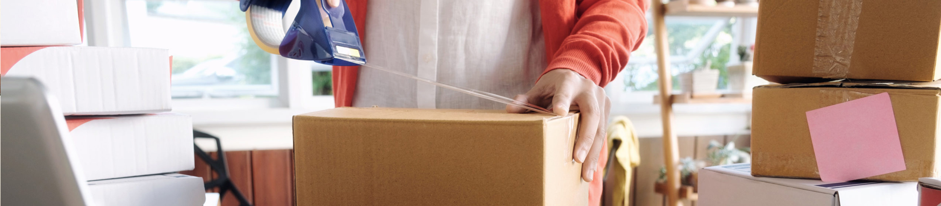 person packing a box for moving
