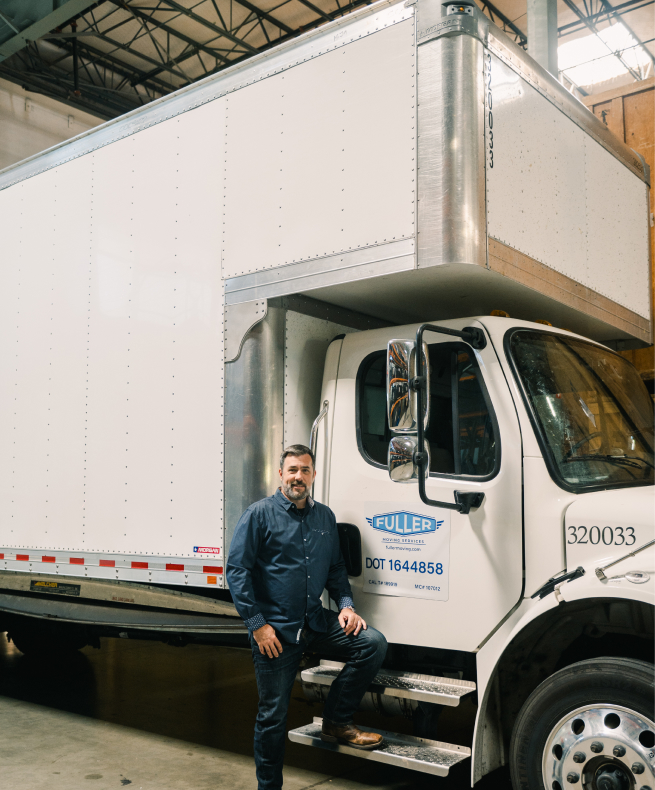 Fuller Moving Services owner Nathan Fuller standing in front of a Fuller Moving Services truck